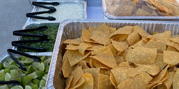 Taqueria Mixteca catering set up. Tray of chips, limes, cilantro, onions.