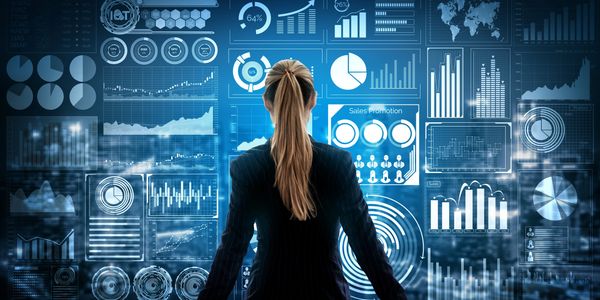 Businesswoman analyzing futuristic data and sales charts on a digital interface.