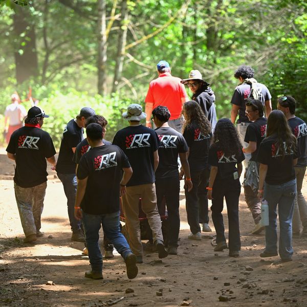 Group of people walking on a forest path.