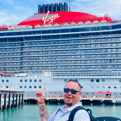Man pointing excitedly at a large Virgin cruise ship.