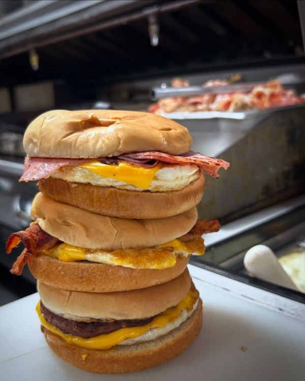 3 breakfast sandwiches stacked. Ham, Bacon, and Sausage egg and cheese