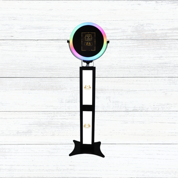 Modern photo booth with colorful ring light and touch screen.