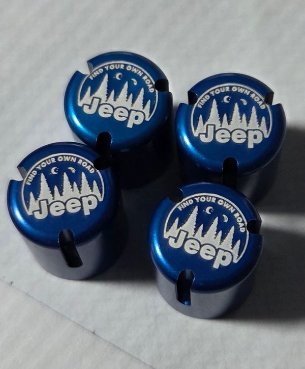 Blue Jeep valve stem caps with "Find Your Own Road" design.
