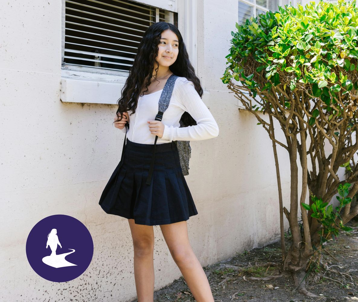 Young woman with long hair wearing a skirt and backpack outdoors.