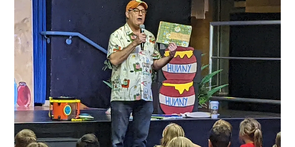 Best-selling author DJ Steinberg presenting his first book made in 2nd grade at a school assembly