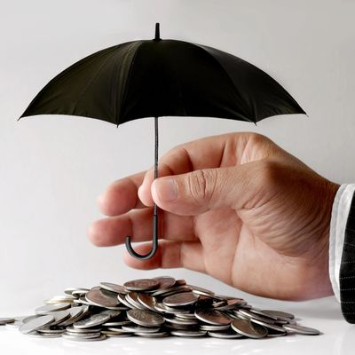 Businessman Protecting Coins With Umbrella. Financial safety Concept.