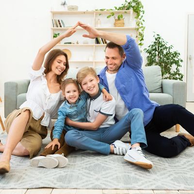 Parents Making Symbolic Roof Joining Hands Above Kids Sitting Indoors