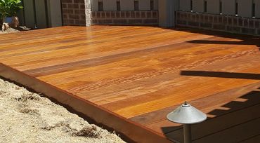 Newly installed polished wooden deck in sunlight.