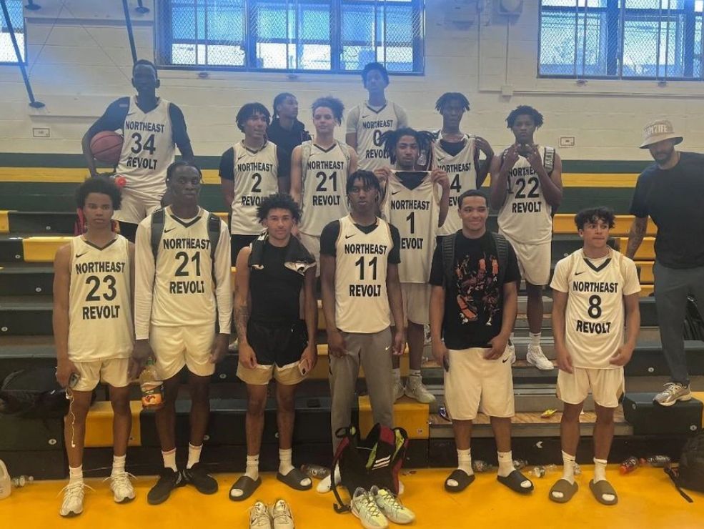 Basketball team posing in gym bleachers.