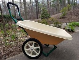 4 cubic foot load dumper in front of a garden
