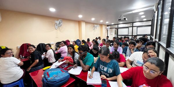 A crowded classroom with students engaged in study and note-taking.