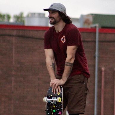 Mathieu Cyr avec un T-Shirt et un skateboard Comeback Skateboards.
