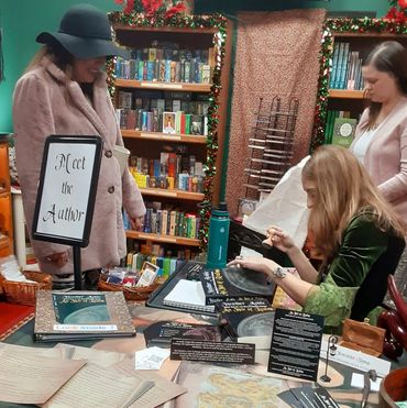Author Heather Ashle, sales assistant, and a new reader at a book signing at the Crystal Cauldron