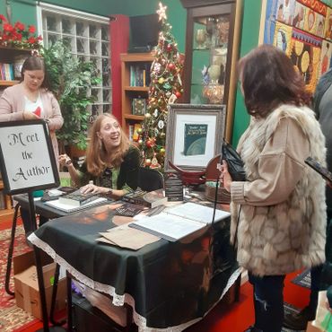 Author Heather Ashle, sales assistant, and a new reader at a book signing at the Crystal Cauldron