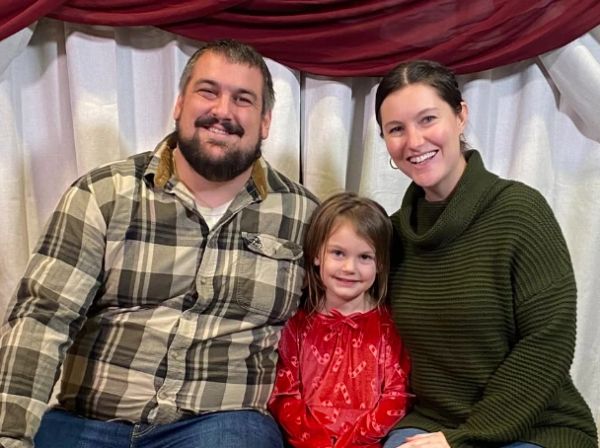 Happy family portrait with a smiling couple and their child.