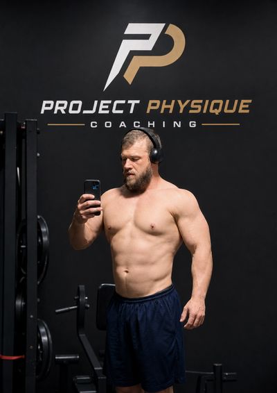 Muscular man taking a selfie in a gym.