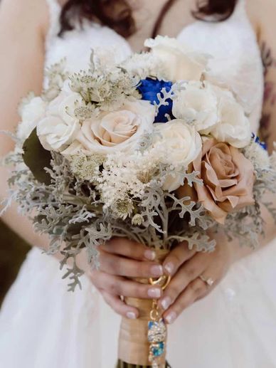 floral of ivory, blush, and soft champagne blooms with delicate textures and a subtle pop of blue