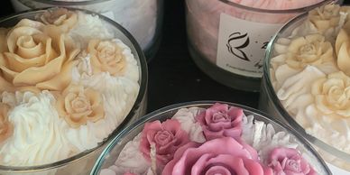Decorative candles with intricate rose designs in various pastel colors.