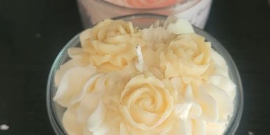 Decorative candles with intricate flower designs in glass containers.