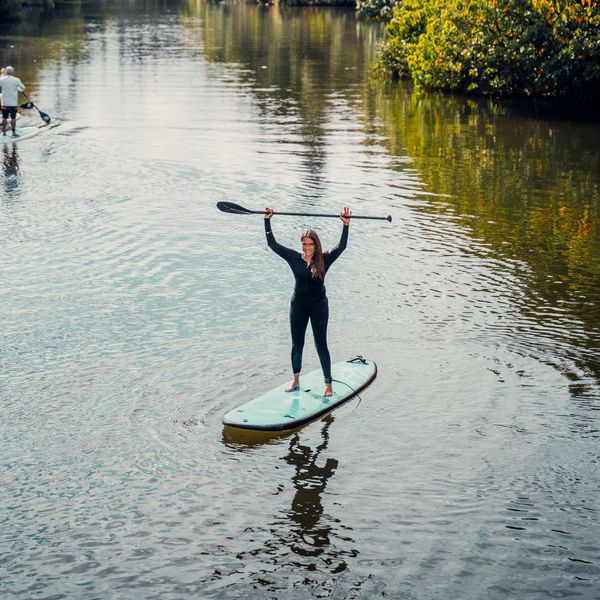 Woman enjoying a solo SUP session at sunrise