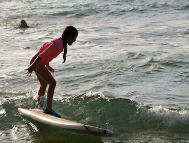 Surfer carving through wave on teal surfboard