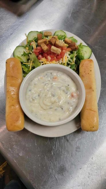 Bowl of soup, side salad, and two breadsticks.