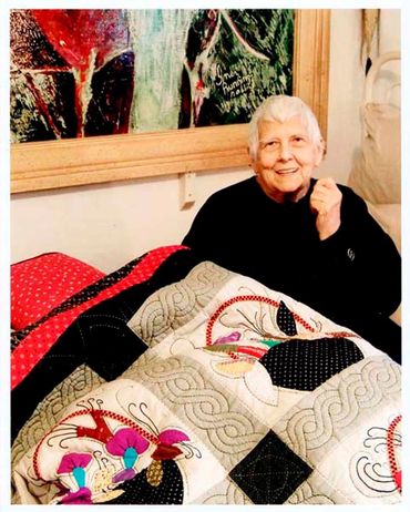 Inez with a third quilt she made by hand.