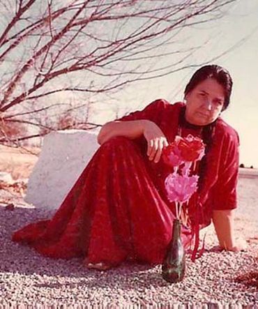 Inez in a red dress with  large  paper flowers that she made herself.