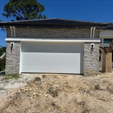 Modern house garage with stone facade under construction.