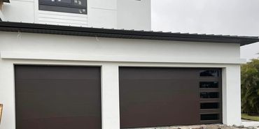 Modern house with two dark brown garage doors under a white facade.