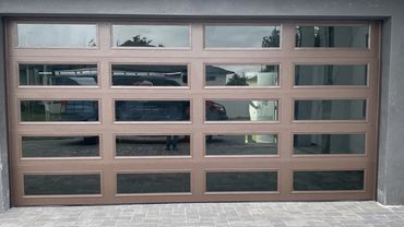 Modern brown garage door with rectangular glass panels.
