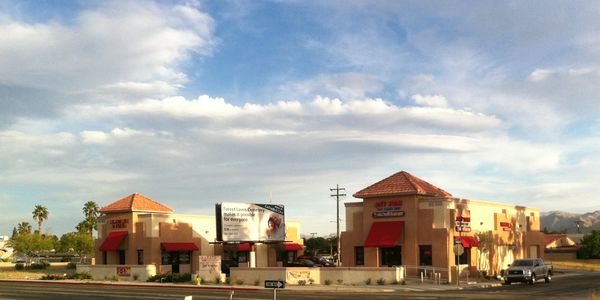 Commercial buildings under a partly cloudy sky.
