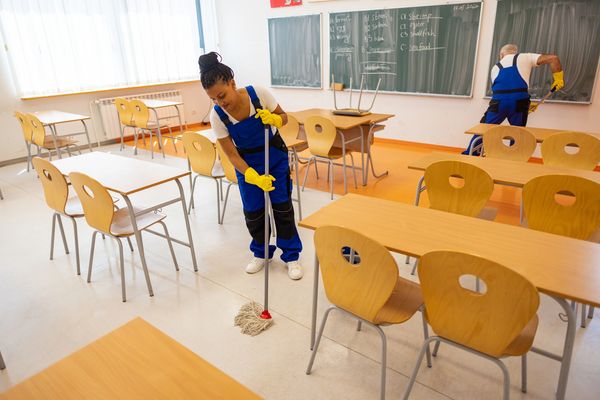 Custodian Mopping Classroom Floor While Coworker Sweeps