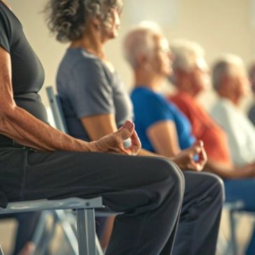 Groupe de personnes âgées méditant assises sur des chaises.