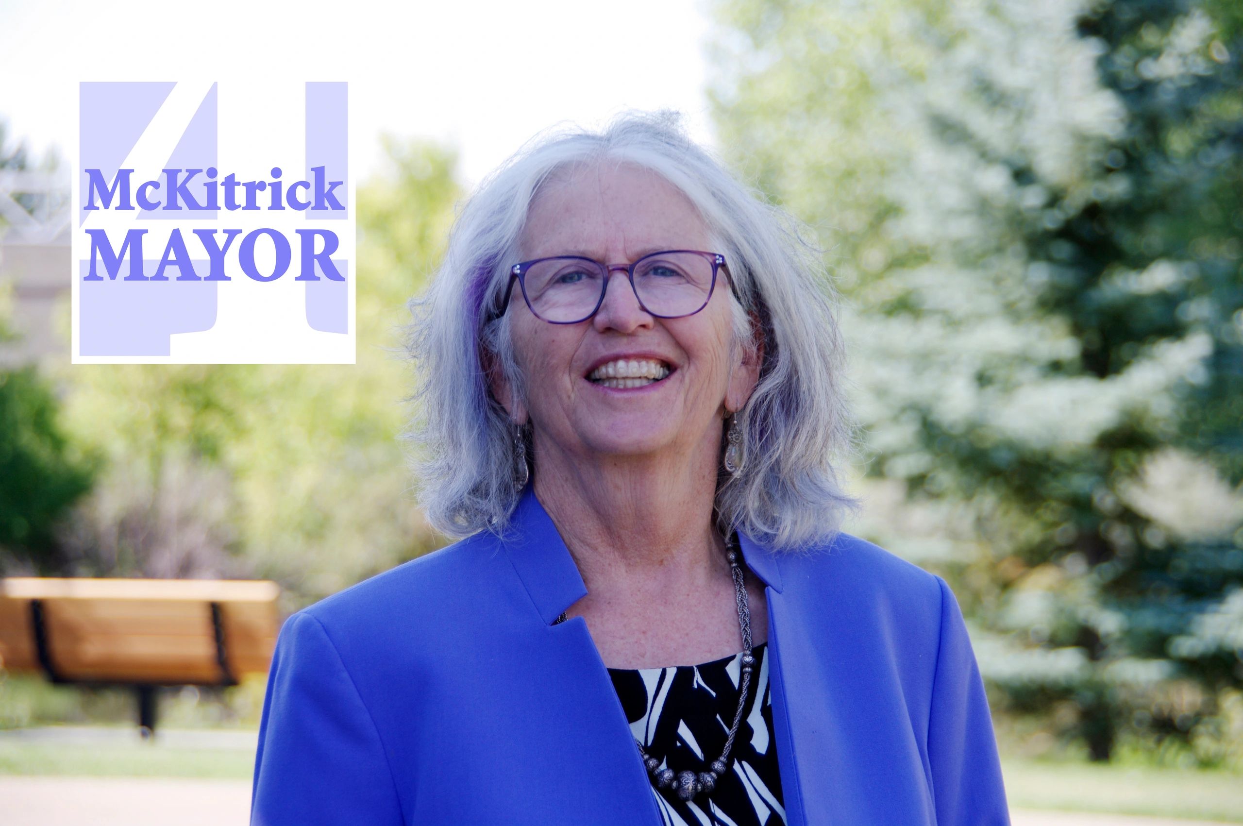 Annie McKitrick in a purple jacket, outside Festival Place/McKitrick 4 Mayor logo in the top corner