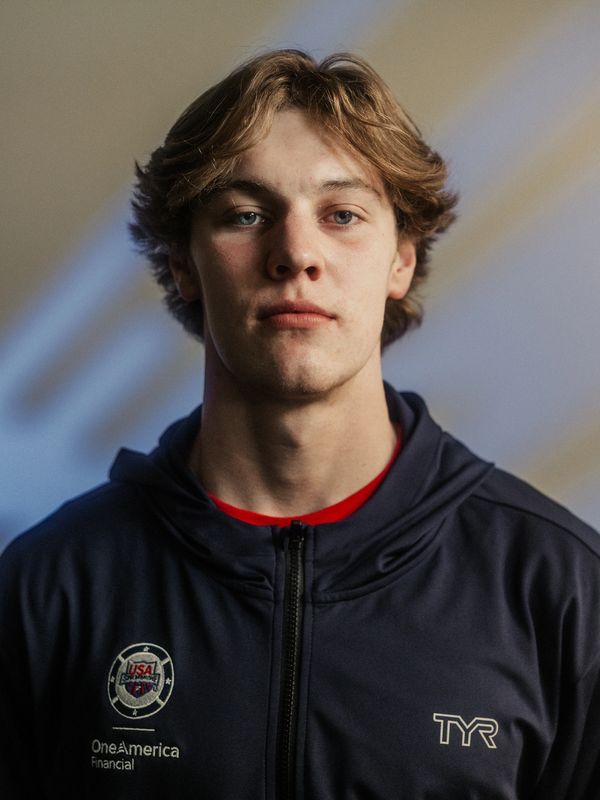 Young man in a navy jacket with USA emblem.