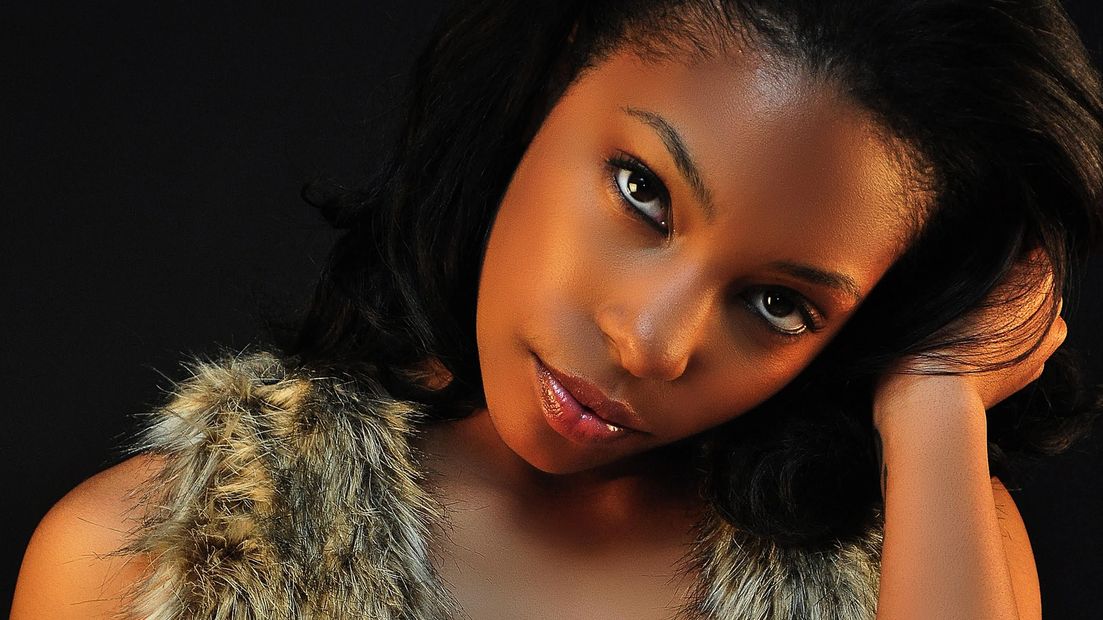 Faux fur vest, sultry stare, hip tattoo