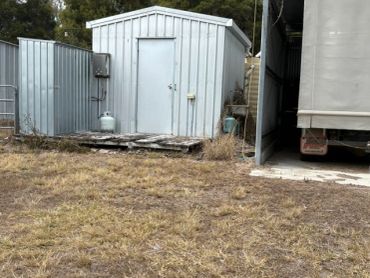 Metal sheds and a truck parked beside them.