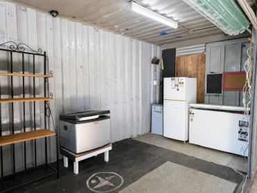 Empty storage room with appliances and shelves.