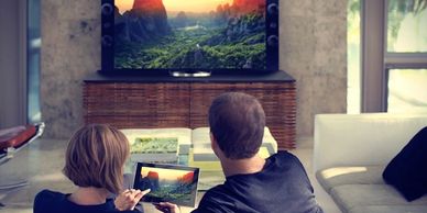 Couple watching Discount TV on their smart TV and tablet.