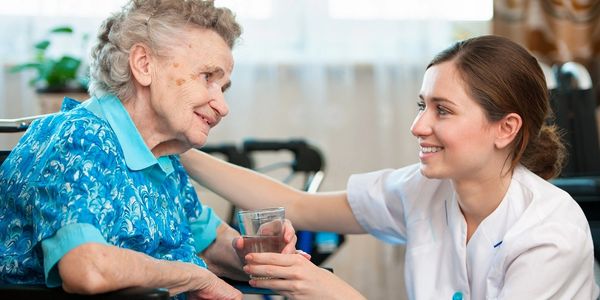 Nurse in white uniform with happy elderly woman