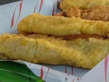 Three pieces of fried fish on a paper lining.