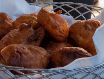 Basket of golden brown fried fritters.