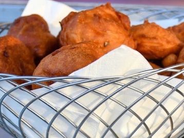 Close-up of fried dough balls on a wire rack.