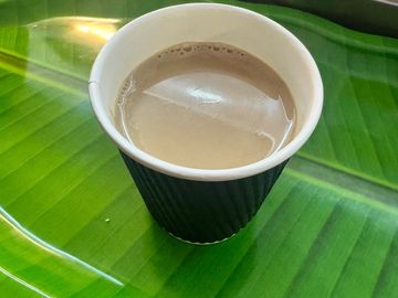 Cup of tea on a green banana leaf.