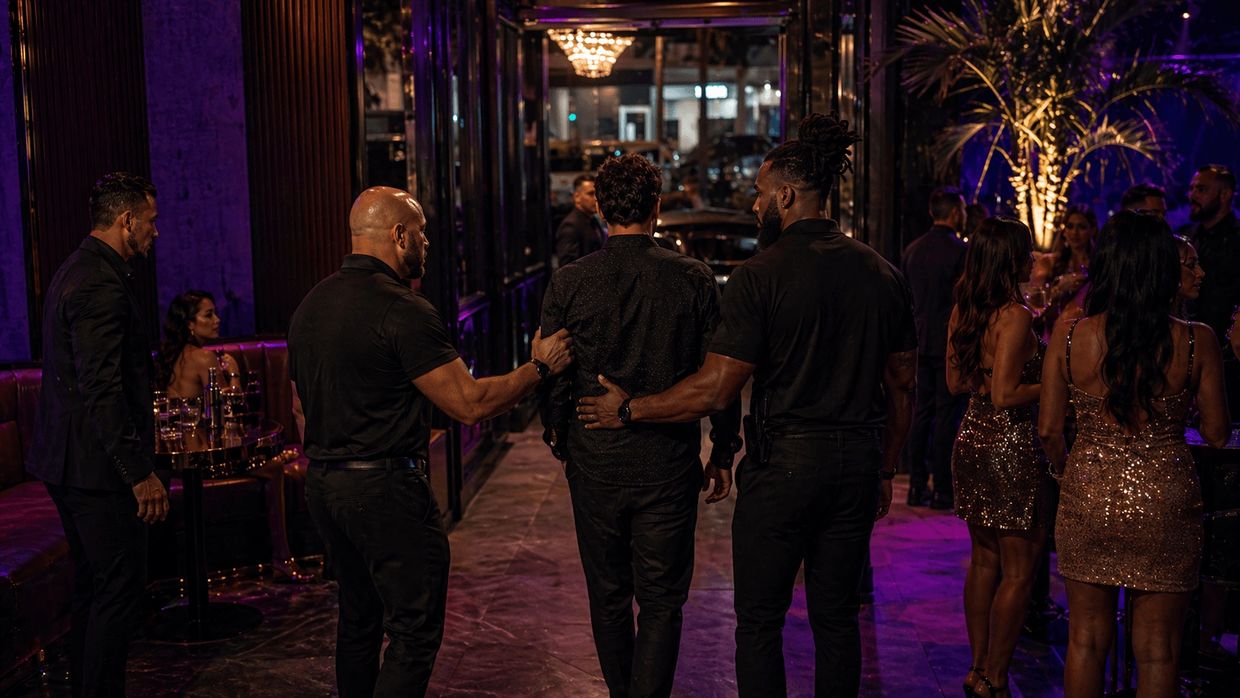 security escorting a guest out of an upscale nightclub in a controlled professional manner