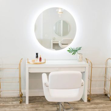 A desk of the white table and white chair for guests of the salon