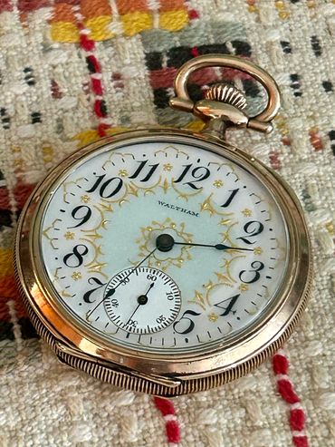 Vintage Waltham pocket watch with intricate gold detailing.