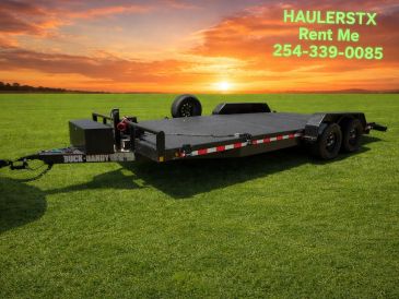Flatbed trailer on grass with sunset and rental contact info.
