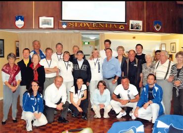 Group photo of people in a room with a Slovenia sign above.